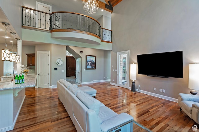 963 E Old English Rd, Draper, UT 84020 - living room featuring a chandelier, wood finished floors, a towering ceiling, and baseboards