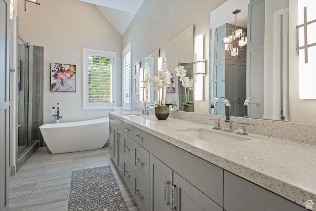 963 E Old English Rd, Draper, UT 84020 - bathroom with double vanity, a soaking tub, a chandelier, a shower stall, and lofted ceiling