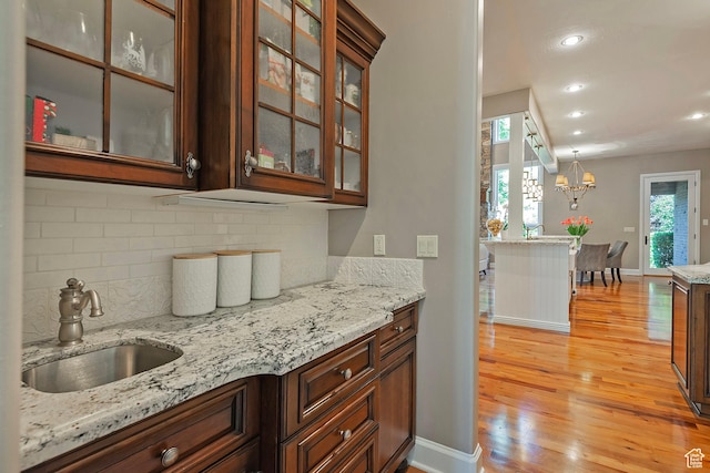 963 E Old English Rd, Draper, UT 84020 - kitchen with a sink, light wood-type flooring, decorative backsplash, light stone countertops, and recessed lighting