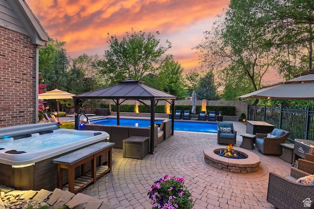 963 E Old English Rd, Draper, UT 84020 - pool at dusk with a gazebo, a hot tub, a fire pit, and a patio area