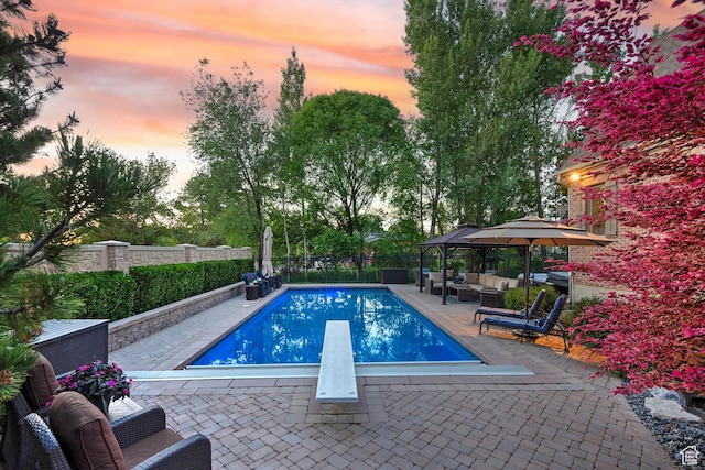 963 E Old English Rd, Draper, UT 84020 - pool at dusk with outdoor lounge area, a diving board, a patio, and a fenced backyard