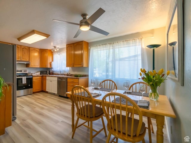 2567 W 2975 S, West Valley City, UT 84119 - kitchen featuring stainless steel appliances, under cabinet range hood, a sink, light wood-style floors, and ceiling fan