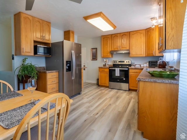 2567 W 2975 S, West Valley City, UT 84119 - kitchen featuring appliances with stainless steel finishes, under cabinet range hood, light wood-style floors, a sink, and baseboards