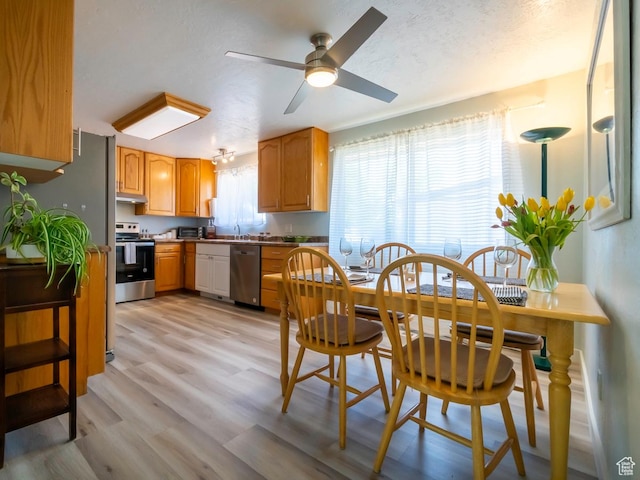 2567 W 2975 S, West Valley City, UT 84119 - kitchen featuring stainless steel appliances, ceiling fan, light wood finished floors, under cabinet range hood, and a textured ceiling