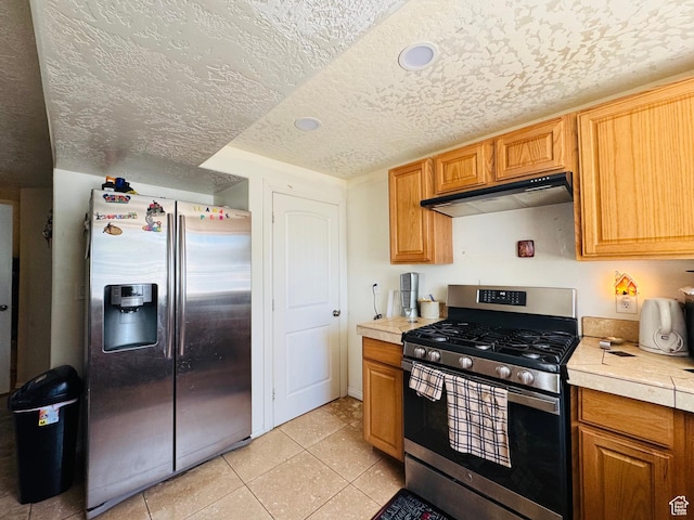 2552 W 2025 N, Clinton, UT 84015 - kitchen featuring appliances with stainless steel finishes, under cabinet range hood, light countertops, light tile patterned floors, and a textured ceiling