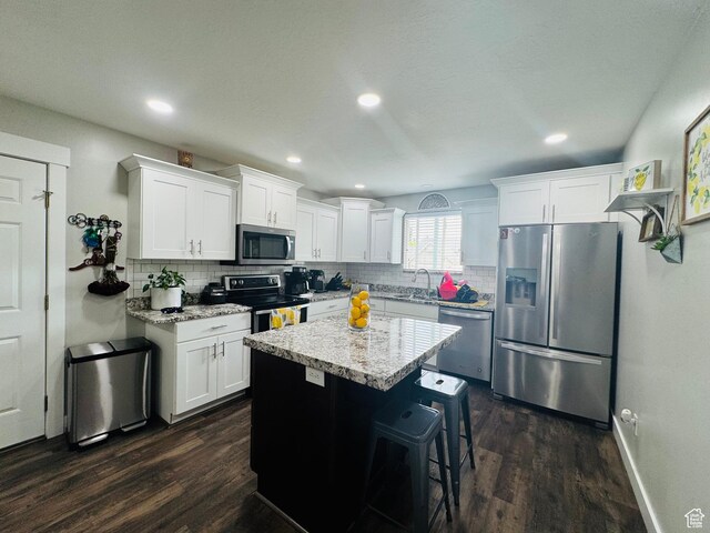 2552 W 2025 N, Clinton, UT 84015 - kitchen featuring stainless steel appliances, dark wood-style flooring, decorative backsplash, a sink, and white cabinetry