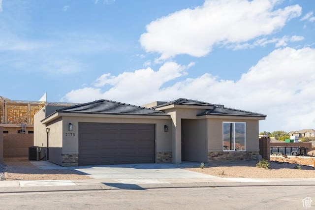 2175 W 320 S, Hurricane, UT 84737 - view of front of home with stone siding, central air condition unit, a garage, driveway, and stucco siding