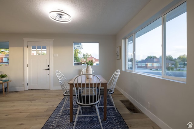 21 E 8680 S, Sandy, UT 84070 - dining room featuring light wood-style floors, healthy amount of natural light, baseboards, and a textured ceiling