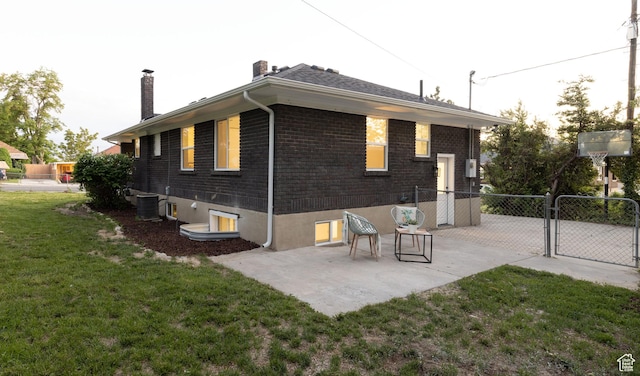 21 E 8680 S, Sandy, UT 84070 - back of property with a chimney, a gate, brick siding, central AC unit, and a patio