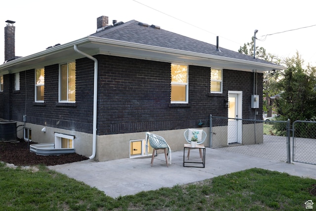 21 E 8680 S, Sandy, UT 84070 - rear view of house with a chimney, a patio area, brick siding, a gate, and central AC unit