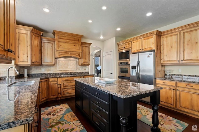 14248 Tumbleweed Way, Draper, UT 84020 - kitchen featuring stainless steel appliances, a sink, dark wood-style flooring, arched walkways, and decorative backsplash