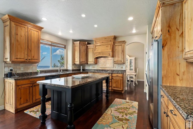 14248 Tumbleweed Way, Draper, UT 84020 - kitchen with freestanding refrigerator, decorative backsplash, recessed lighting, dark wood-style floors, and arched walkways