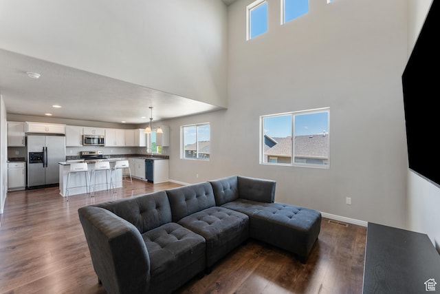 2956 S Willow Creek Dr, Saratoga Springs, UT 84045 - living room featuring dark wood-style floors, a chandelier, baseboards, recessed lighting, and a high ceiling