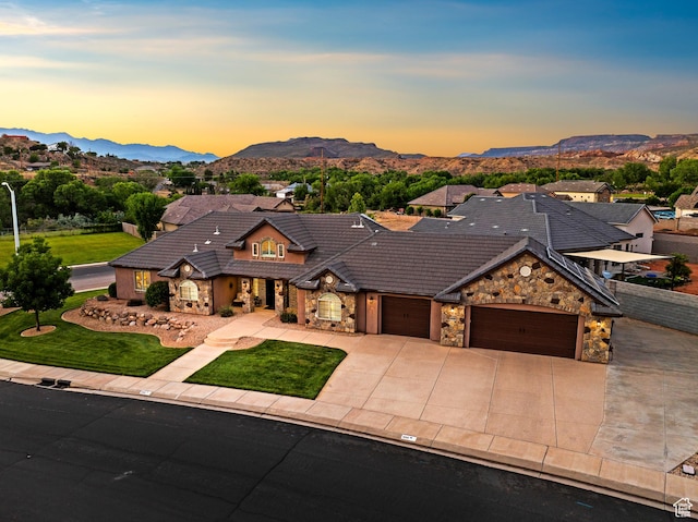 880 N 370 W, La Verkin, UT 84745 - view of front facade featuring stone siding, an attached garage, a mountain view, driveway, and a tile roof