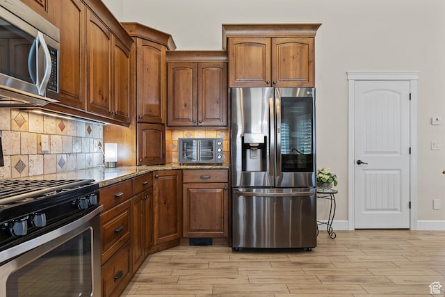 880 N 370 W, La Verkin, UT 84745 - kitchen with appliances with stainless steel finishes, light stone counters, light wood-type flooring, tasteful backsplash, and baseboards
