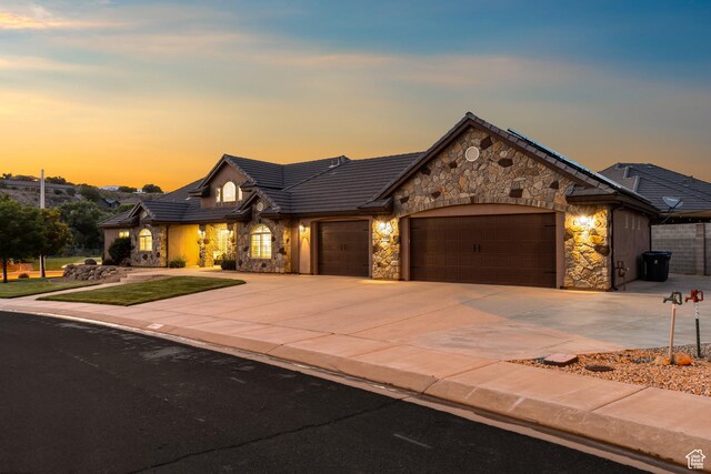 880 N 370 W, La Verkin, UT 84745 - view of front of property featuring stone siding, a garage, driveway, a front yard, and a tile roof