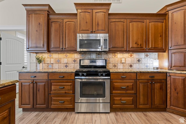 880 N 370 W, La Verkin, UT 84745 - kitchen with appliances with stainless steel finishes, light stone counters, backsplash, and light wood-style flooring