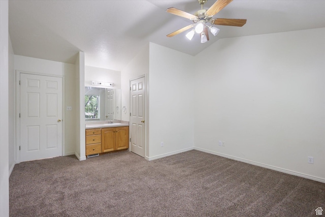894 N Main St Unit 13, Orem, UT 84057 - unfurnished bedroom featuring dark carpet, vaulted ceiling, baseboards, a sink, and connected bathroom