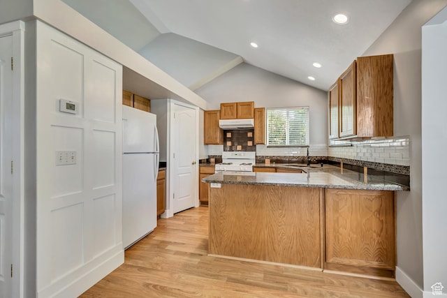 13928 S Ben Lomond Peak Dr W, Riverton, UT 84096 - kitchen with white appliances, under cabinet range hood, a peninsula, dark stone counters, and lofted ceiling