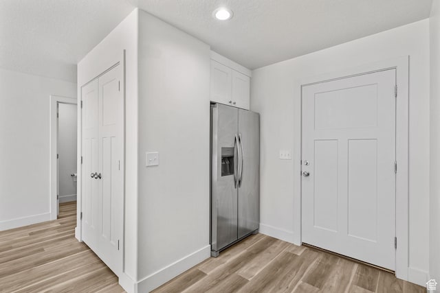 917 N 100 W, Nephi, UT 84648 - kitchen with stainless steel fridge, light wood-style flooring, white cabinets, baseboards, and a textured ceiling