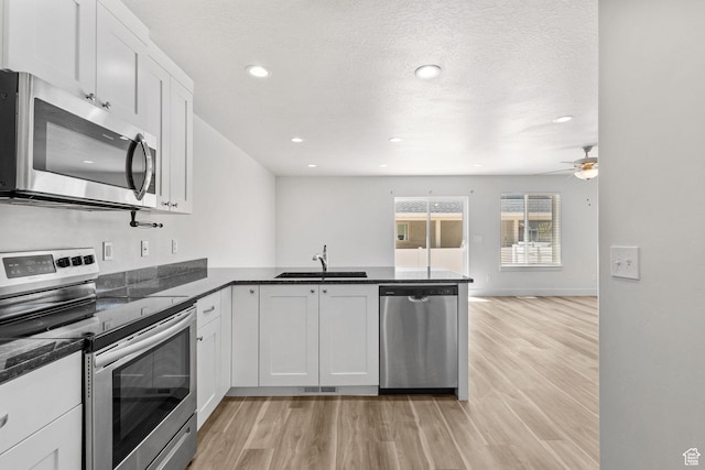 917 N 100 W, Nephi, UT 84648 - kitchen with appliances with stainless steel finishes, a sink, a peninsula, light wood finished floors, and recessed lighting