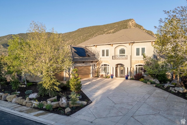 2204 N Bridge Water Rd, Cedar City, UT 84721 - mediterranean / spanish-style home with driveway, roof mounted solar panels, stucco siding, and a mountain view