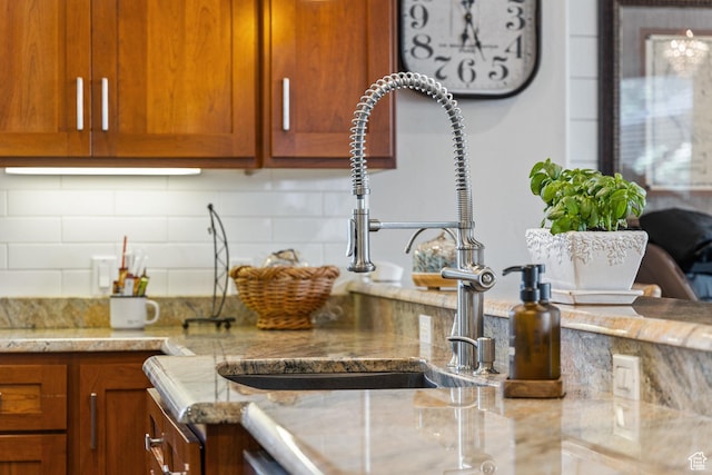 2204 N Bridge Water Rd, Cedar City, UT 84721 - kitchen featuring decorative backsplash, a sink, and brown cabinetry