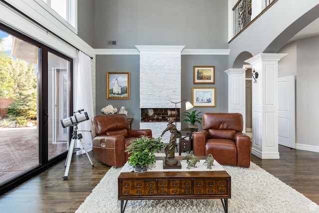 2204 N Bridge Water Rd, Cedar City, UT 84721 - living room featuring a high ceiling, arched walkways, ornate columns, dark wood-style flooring, and baseboards