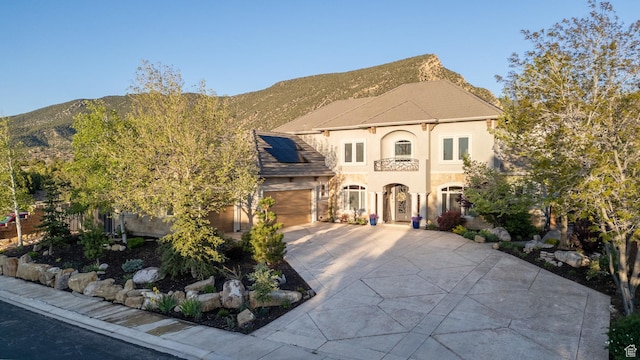 2204 N Bridge Water Rd, Cedar City, UT 84721 - view of front of property featuring driveway, solar panels, stucco siding, a mountain view, and an attached garage