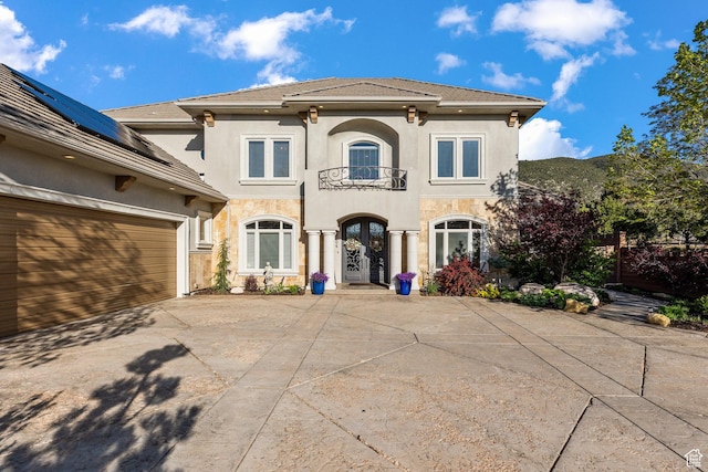 2204 N Bridge Water Rd, Cedar City, UT 84721 - back of house featuring a balcony, stucco siding, driveway, a garage, and solar panels