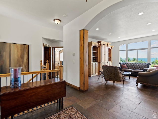 5577 E Elkhorn Dr, Eden, UT 84310 - living room featuring arched walkways, recessed lighting, baseboards, stone tile floors, and a textured ceiling