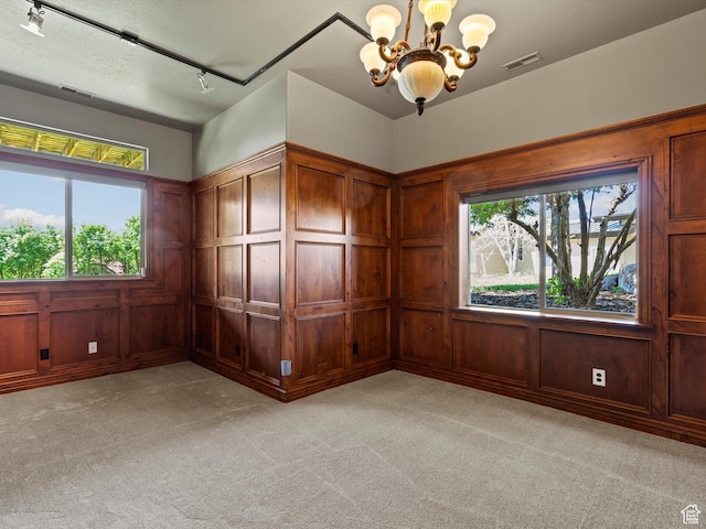 5577 E Elkhorn Dr, Eden, UT 84310 - spare room with a chandelier, a decorative wall, light colored carpet, and rail lighting