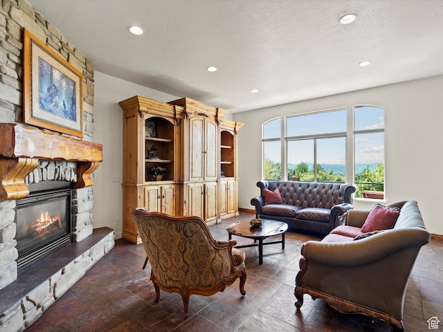 5577 E Elkhorn Dr, Eden, UT 84310 - living room featuring stone tile flooring, a fireplace, recessed lighting, baseboards, and a textured ceiling