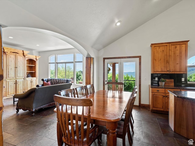 5577 E Elkhorn Dr, Eden, UT 84310 - dining space with stone tile floors, vaulted ceiling, arched walkways, recessed lighting, and baseboards