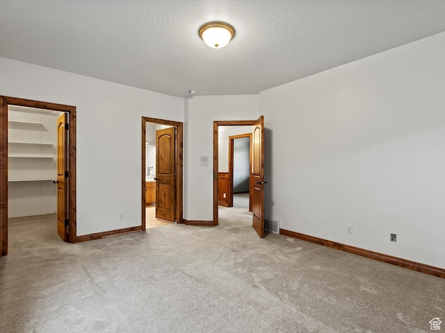 5577 E Elkhorn Dr, Eden, UT 84310 - unfurnished bedroom with a spacious closet, light colored carpet, baseboards, a closet, and a textured ceiling