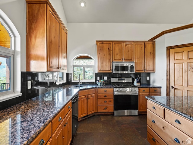 5577 E Elkhorn Dr, Eden, UT 84310 - kitchen featuring stainless steel appliances, decorative backsplash, brown cabinetry, dark stone counters, and a sink