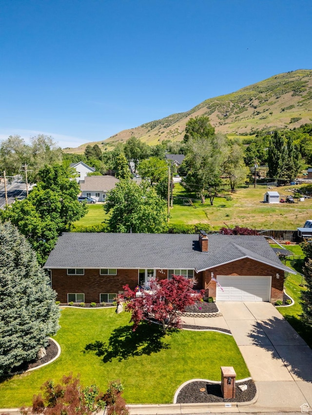 1607 Mountain Cir, Fruit Heights, UT 84037 - view of front of home featuring a mountain view, driveway, a front lawn, brick siding, and a garage