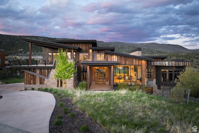 942 N Explorer Peak Dr Unit 420, Heber City, UT 84032 - back of house at dusk featuring stone siding, a chimney, and a mountain view