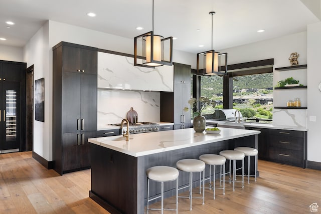 942 N Explorer Peak Dr Unit 420, Heber City, UT 84032 - kitchen with an island with sink, light wood-style floors, a kitchen breakfast bar, decorative backsplash, and open shelves