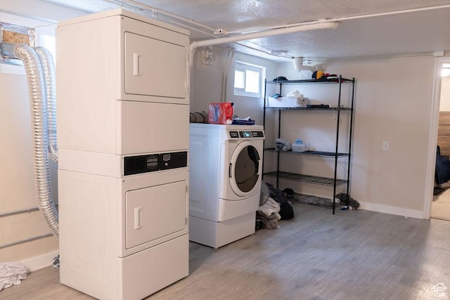 1444 S Beacon Dr E, Salt Lake City, UT 84108 - laundry area with stacked washer / drying machine, light wood finished floors, and baseboards