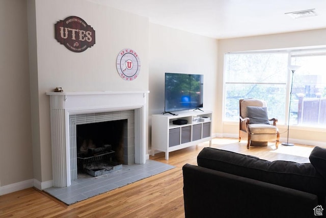 1444 S Beacon Dr E, Salt Lake City, UT 84108 - living area with wood finished floors, a tiled fireplace, and plenty of natural light