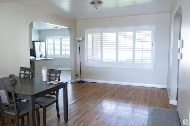 1444 S Beacon Dr E, Salt Lake City, UT 84108 - dining area featuring arched walkways, wood finished floors, and baseboards