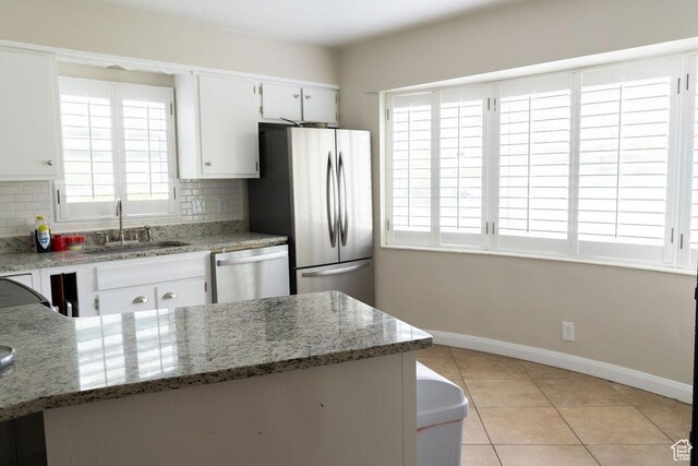 1444 S Beacon Dr E, Salt Lake City, UT 84108 - kitchen featuring a sink, stainless steel appliances, baseboards, tasteful backsplash, and light tile patterned floors