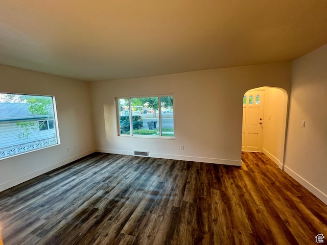 144 S 100 W, Tremonton, UT 84337 - spare room with arched walkways, plenty of natural light, dark wood-style flooring, and baseboards