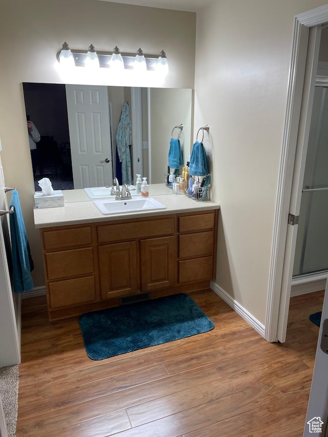 536 E 2200 N, North Ogden, UT 84414 - bathroom featuring wood finished floors, vanity, baseboards, and a shower with shower door