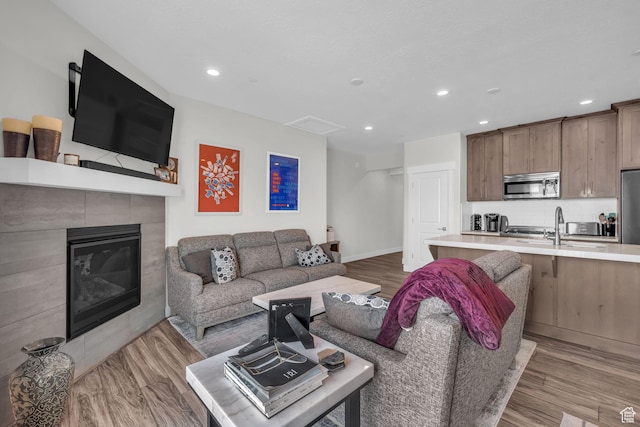 3041 Cedar Dr, Park City, UT 84098 - living room featuring light wood-style floors, recessed lighting, a tiled fireplace, and baseboards