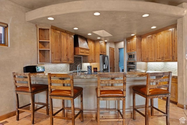 2405 W Entrada Trl Unit 76, St George, UT 84770 - kitchen with stainless steel appliances, custom range hood, a peninsula, recessed lighting, and decorative backsplash