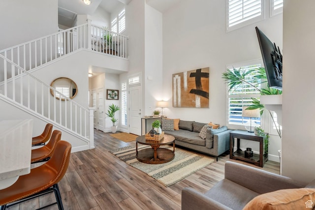 10394 S Crow Wing Dr, South Jordan, UT 84009 - living room with a towering ceiling, stairs, wood finished floors, and baseboards