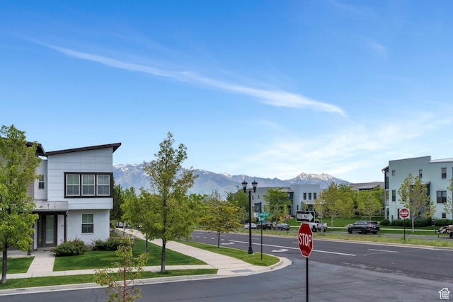 10394 S Crow Wing Dr, South Jordan, UT 84009 - view of asphalt street featuring traffic signs, street lighting, a mountain view, and curbs