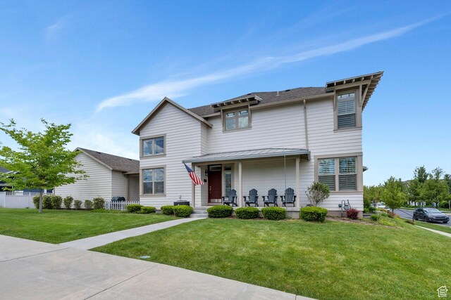 10394 S Crow Wing Dr, South Jordan, UT 84009 - traditional home with a porch, a front lawn, and a standing seam roof